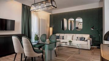 Una sala de estar moderna con una mesa de centro de vidrio, un sofá y un comedor con sillas.