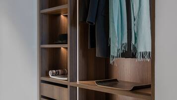 Un placard moderne doté de nombreuses étagères et d’un espace pour suspendre les vêtements, avec une finition en bois et un éclairage intégré.