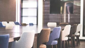 A modern conference room with a long table and multiple chairs.