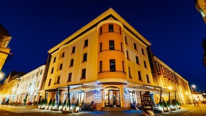 Un hôtel doté d’une façade incurvée, de nombreux balcons et d’espaces extérieurs aménagés pour s’asseoir.