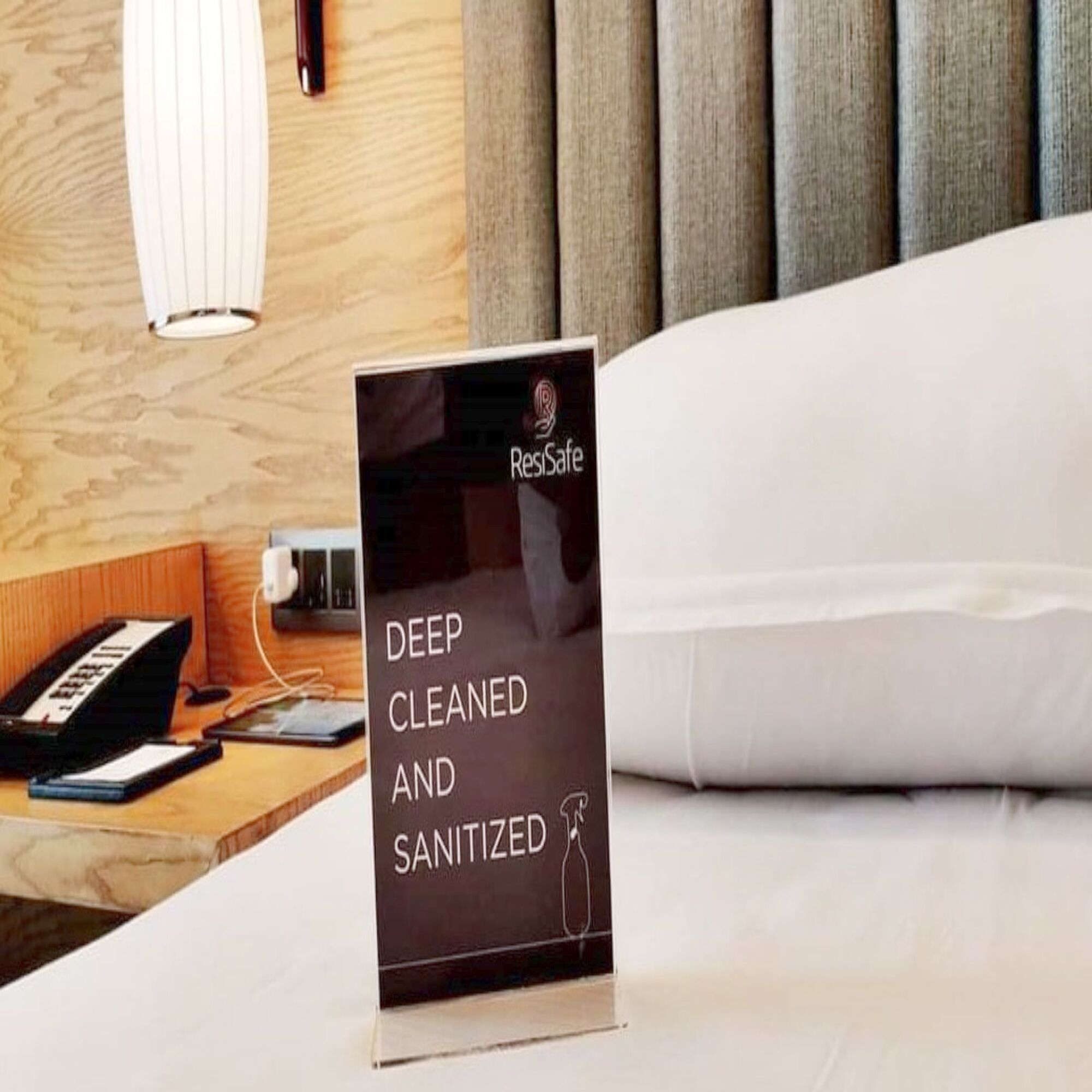 A sign in a hotel room stating "Deep Cleaned and Sanitized" with a logo.