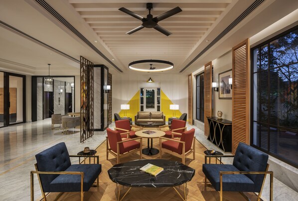 A modern hotel lobby with a central seating area, a ceiling fan, and large windows. - The Residency Towers Puducherry (Puducherry)