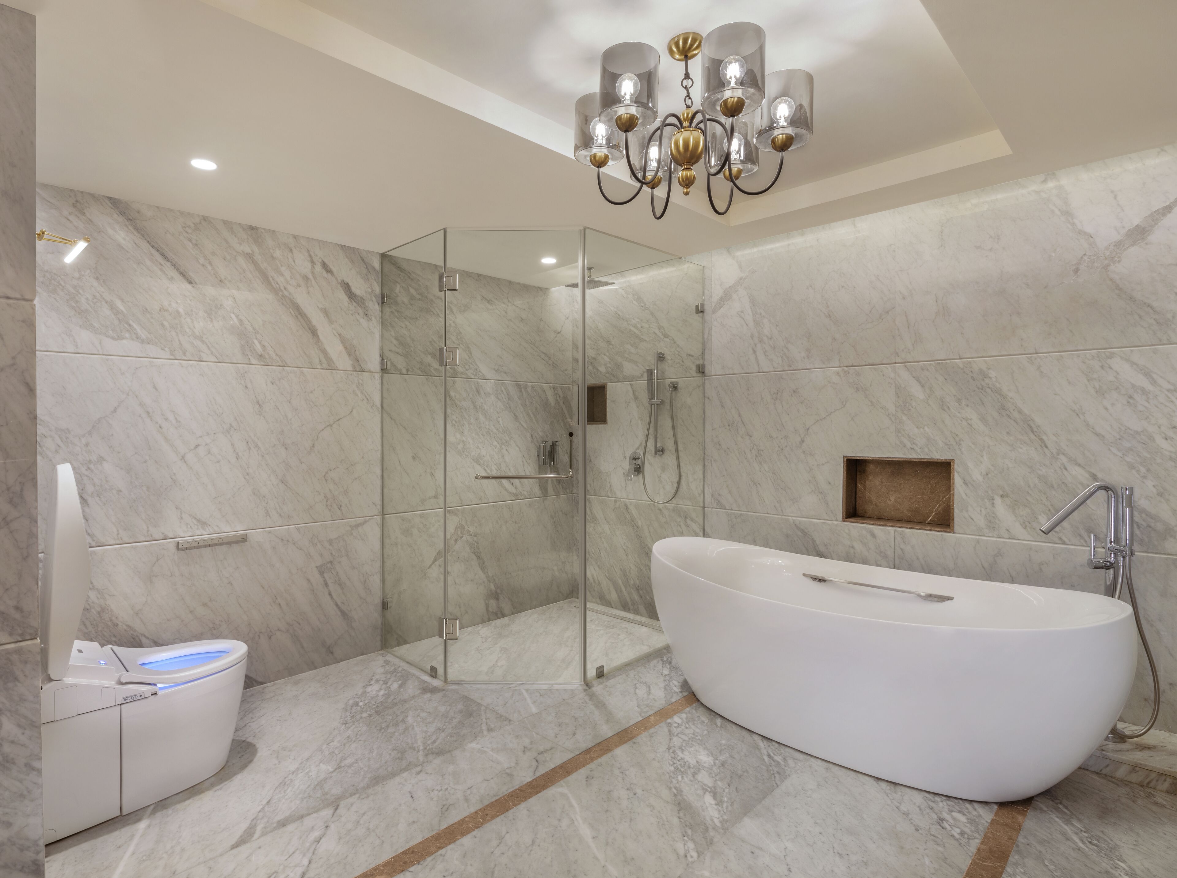 Ein modernes Badezimmer mit einer freistehenden Badewanne, einer gläsernen Duschkabine und einem WC mit Bedienfeld.