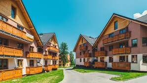 Een rij houten gebouwen met balkons, een heldere lucht en een verharde looppad.