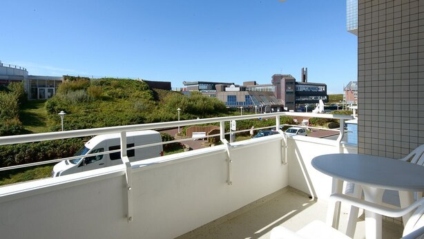 A balcony with a view of a parking area and buildings. - App. Kohfahl 65, Germany (Sylt)