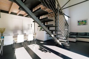 Un intérieur moderne avec un escalier, un coin repas et un canapé.