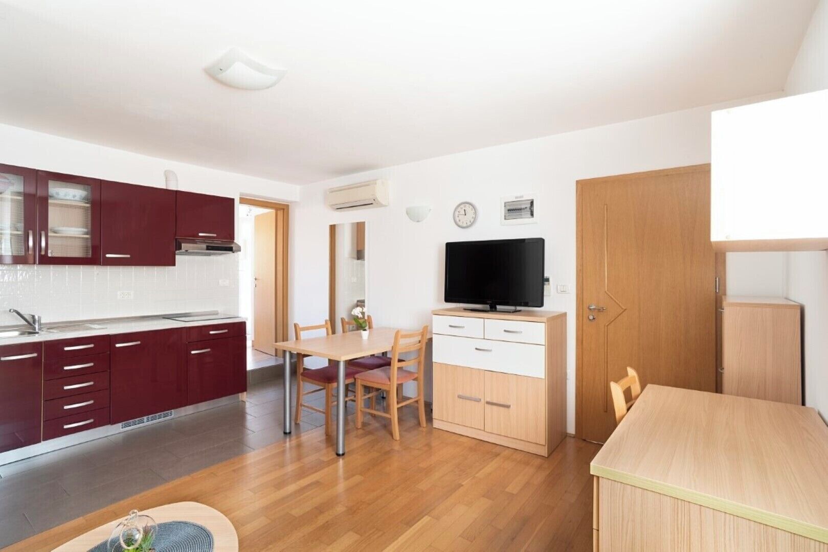 A compact living space with a kitchen, dining area, and a TV.