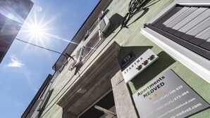 Un edificio con un'insegna che indica 'Apartments MEDVED', con informazioni di contatto e un sito web.
