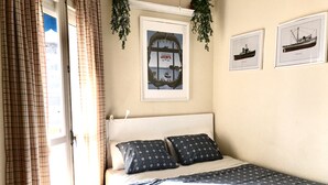 A bedroom with a bed, curtains, a framed poster, and a hanging plant. - Beachfront house. WIFI. Smart TV (Águilas)