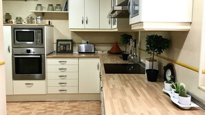 A kitchen with white cabinets, a microwave, an oven, a toaster, and potted plants. - Beachfront house. WIFI. Smart TV (Águilas)