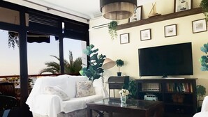 A living room with a sofa, a coffee table, a TV, and a bookshelf. - Beachfront house. WIFI. Smart TV (Águilas)
