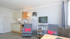 A compact living space with a kitchenette, a dining area, and a seating area with two armchairs and a sofa. - App. Rüter 57, Germany (Sylt)
