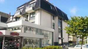 En modern byggnad med en butiksfasad där det står ”RENO”.
