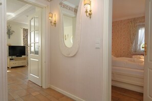 Une chambre d’hôtel avec un grand miroir, une télévision et un lit.
