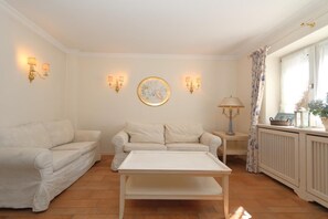 Un salon avec un canapé, une table basse et des lampes fixées au mur.