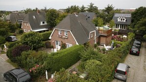 Ett bostadsområde med hus, en trädgård och parkerade bilar.