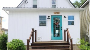 A white house with a turquoise door, numbered 3723, and a wooden staircase leading to the front. - Beautiful lakefront cottage on Chautauqua Lake in a quiet setting! (Jamestown)
