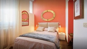 A bedroom with a bed, bedside tables, and a mirror. - Green Nest Apartaments - GREEN NEST (Florence)