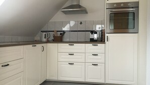 A kitchen with white cabinets, a stainless steel oven, and a tiled backsplash.