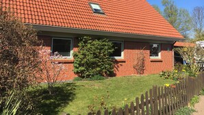A house with a red-tiled roof, brick exterior, and a small window.