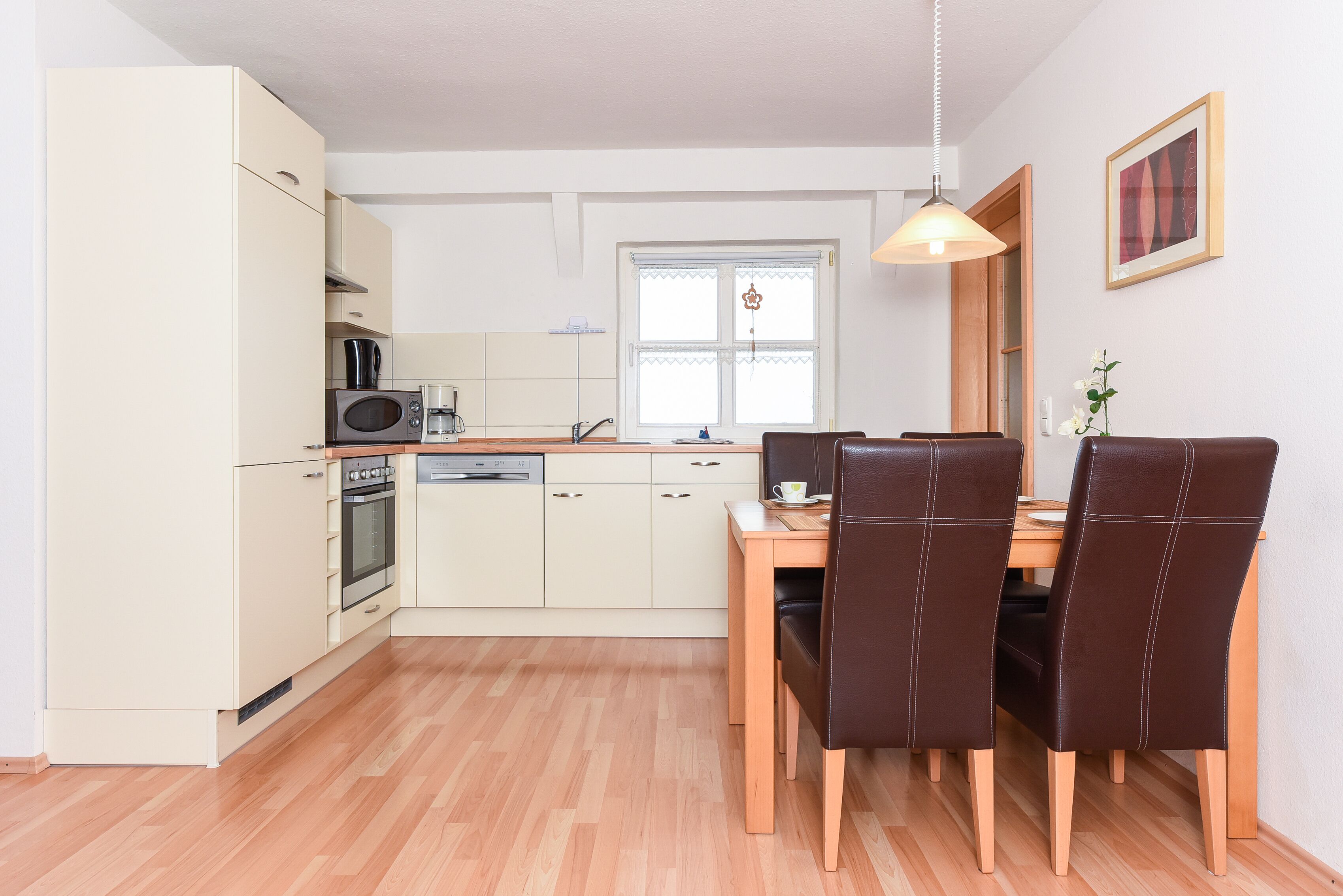 Cocina compacta con comedor, que incluye microondas, horno y pileta.