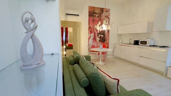 A modern kitchen with white cabinets and a dining area with a round table and chairs.