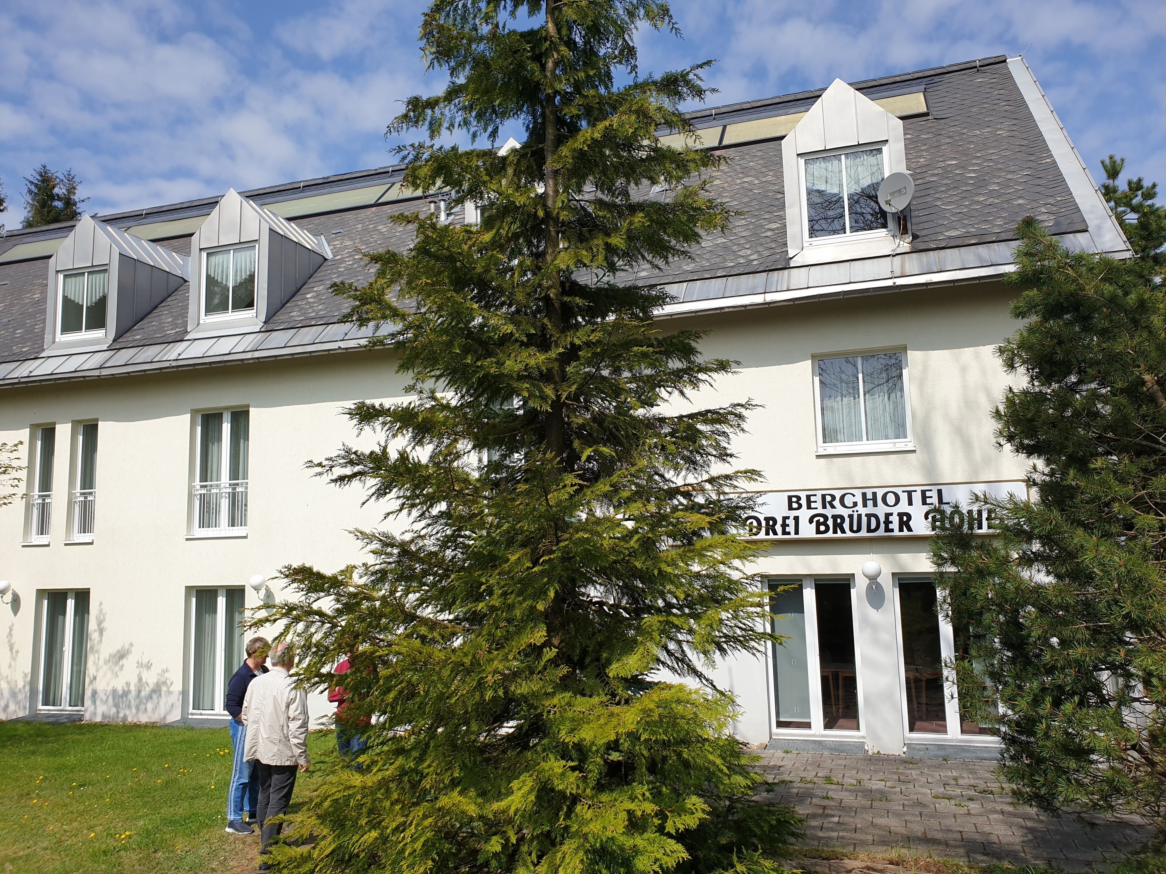 A hotel with a sign reading "BERCHOTEL OREI BRÜDER ROHE".