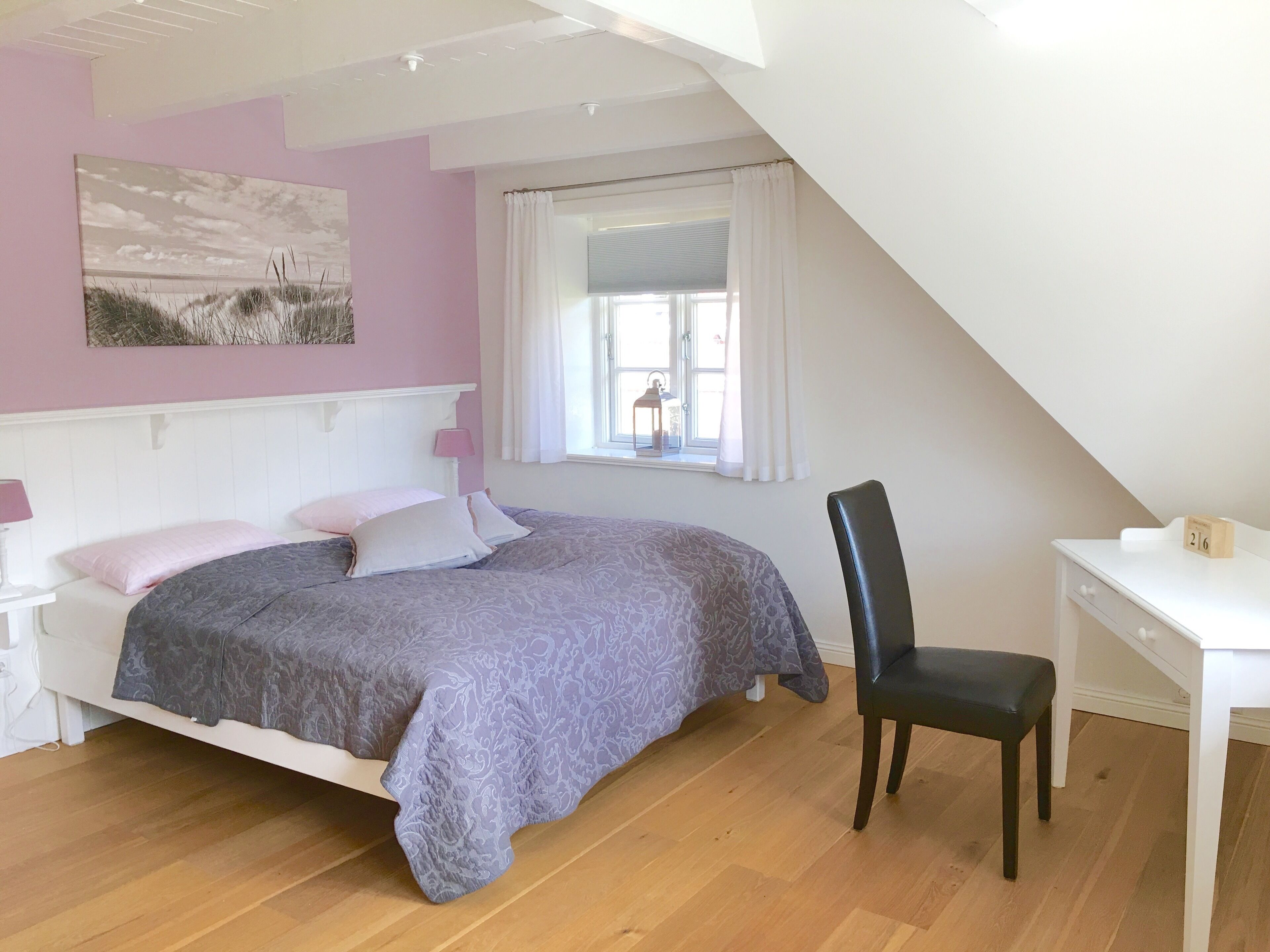 Un dormitorio con una cama, un escritorio y una silla.