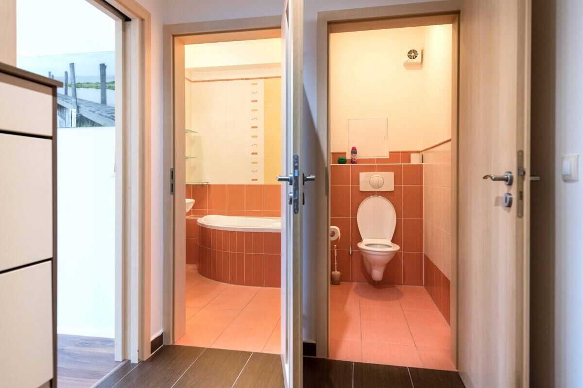 A bathroom with a bathtub, toilet, and a shower area.