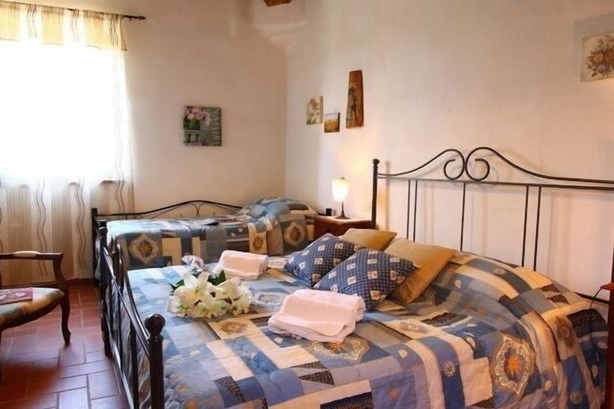 Un dormitorio con dos camas individuales, una silla, una mesita de noche y un tocador.