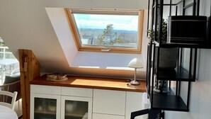 A compact, modern bedroom with a skylight, a white wardrobe, a desk with a lamp, and a black shelving unit. - Magnificent apartment - Beautiful sea view - Wifi included (Quiberon)