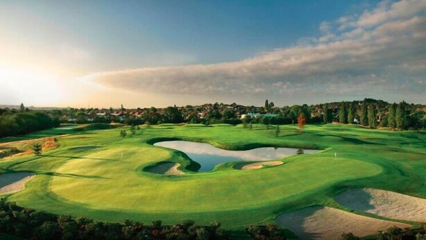 A golf course with bunkers, water hazards, and a distant town. - Northwick Park Apartment (Harrow)