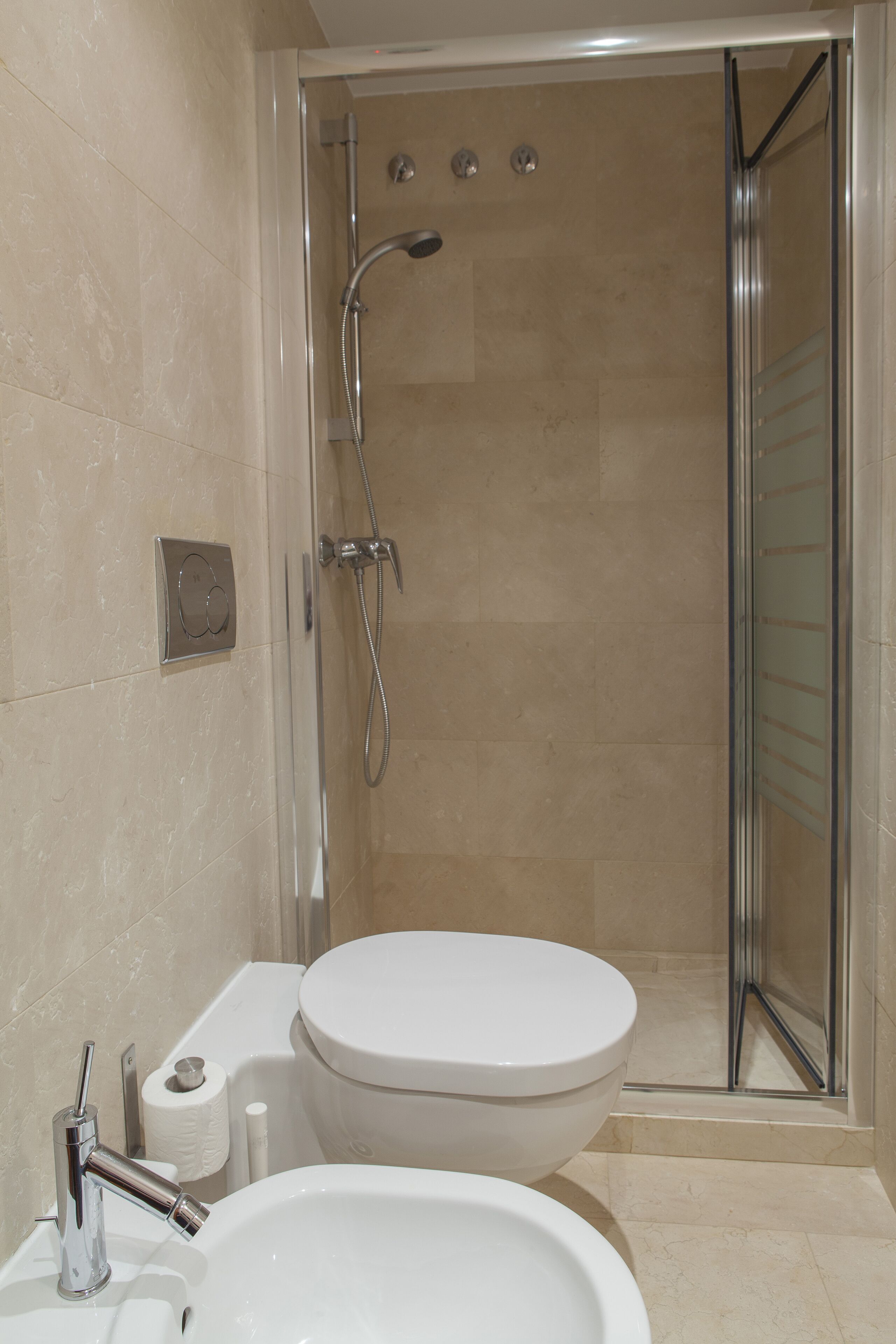 Une salle de bain équipée d’une douche, de toilettes, d’un lavabo et d’un porte-serviettes.