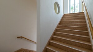 A staircase with a wooden handrail and a round mirror on the wall. - AD Verona Flat (Verona)