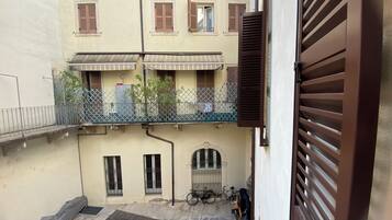 A residential building with a balcony, a bicycle, and a gate.