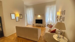 A living room with a sofa, a TV, and a lamp. - AD Verona Flat (Verona)