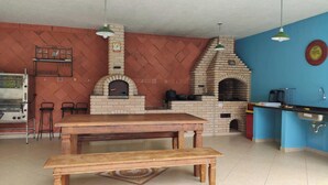 Een keuken met een bakoven, een houten tafel en barstoelen.
