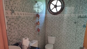 Een badkamer met toilet, hygiëneschuimer en wastafel.