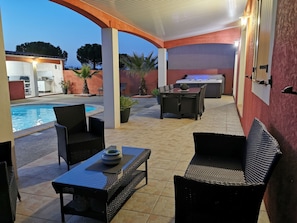 An outdoor patio area with a pool, seating, and a hot tub. - Homerez - Villa in Carcassonne (Carcassonne)