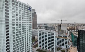 Um hotel moderno com fachada em estrutura geométrica, vários andares e um logotipo Hilton bem visível.
