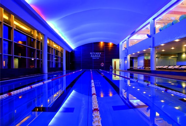 A modern hotel lobby with a central pathway, glass railings, and a visible reception area.
