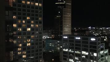 Un paisaje urbano nocturno con edificios altos iluminados, incluyendo un hotel con un letrero destacado.