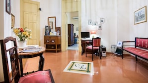 A living room with a wooden desk, a computer, a red sofa, and a chandelier. - La Casa di Zoe (Palermo)