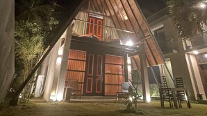 Un edificio moderno con techo triangular, ventanas amplias y un balcón.