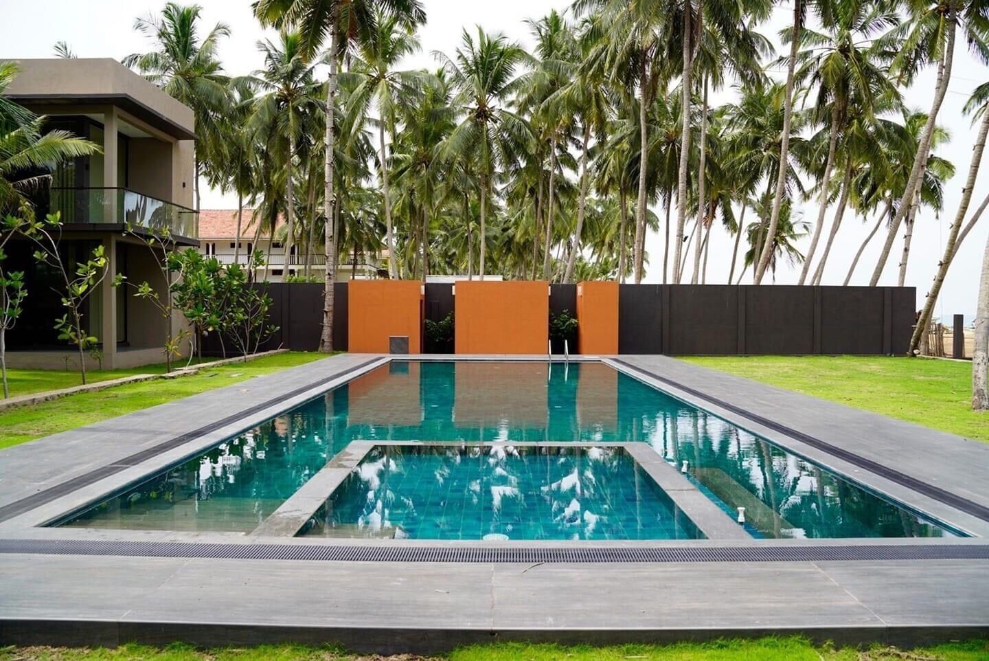 A rectangular swimming pool with a clear blue water surface, surrounded by a low concrete deck.