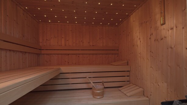 Eine Sauna mit Holzbänken und einem Holzwaschbecken.