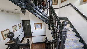 A staircase with black balusters and a checkered carpet. - Cambeth Lodge Guesthouse (Inverness)