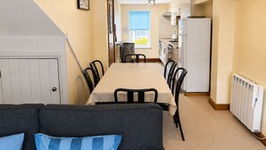 A compact living space with a dining table, chairs, a sofa, and a kitchenette. - Howgills Apartment 9 (self-catering accommodation with free parking and Wi-Fi) (Sedbergh)