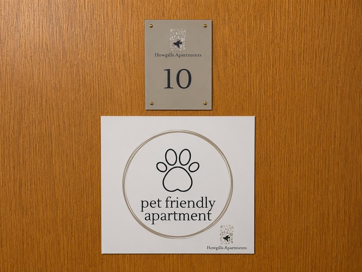 Placa indicando que o apartamento aceita animais de estimação, com o logotipo de uma pata e o texto 'Howgills Apartments' abaixo.