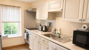 A compact kitchen with a dishwasher, a microwave, a toaster, and a kettle. - Howgills Apartment 11 (self-catering accommodation with free parking and Wi-Fi) (Sedbergh)